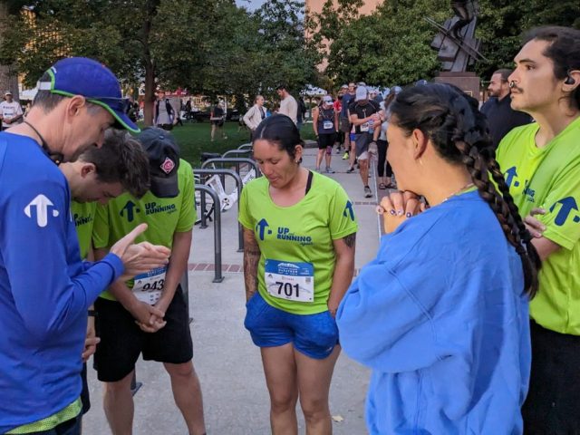 Group of runners praying before a race