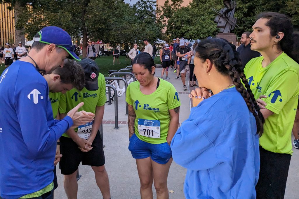 Group of runners praying before a race